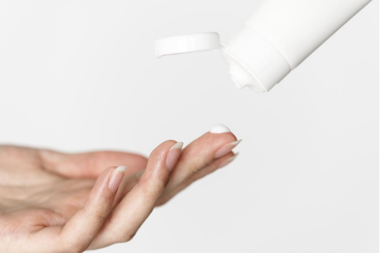 She is applying a moisturizing cream to her hands. She is applying a moisturizing cream to her hands.